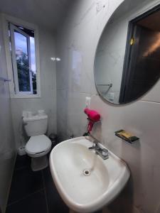 een badkamer met een witte wastafel en een spiegel bij frida in Mexico-Stad