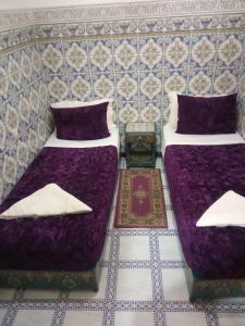 two beds sitting next to each other in a room at Sindi Sud in Marrakesh