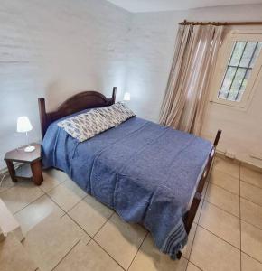 Un dormitorio con una cama con una manta azul. en Descanso en Villa Allende, familia, golf, amigos en Villa Allende
