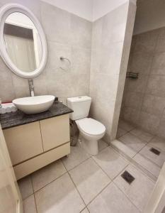 a bathroom with a toilet and a sink and a mirror at Descanso en Villa Allende, familia, golf, amigos in Villa Allende