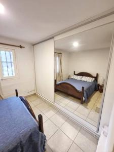 a bedroom with a reflection of a bed in a mirror at Descanso en Villa Allende, familia, golf, amigos in Villa Allende +10 photos