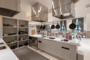 una cocina con encimeras blancas y electrodomésticos de acero inoxidable en Chestertons Sokcho, en Sokcho