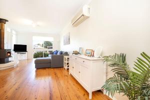 a white living room with a couch and a table at Hayes Beach House I Award Winner I 4 Mins to Beach in Callala Beach