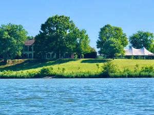 ein Zelt auf einem Hügel neben einem Haus mit See in der Unterkunft Williams Island Room at Tennessee RiverPlace in Chattanooga