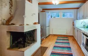 a living room with a fireplace in a kitchen at Amazing Home In Hkerum With Sauna, 3 Bedrooms And Wifi in Hökerum