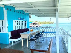 a porch with a table and chairs and the ocean at บ้านในทะเล (Baan Nai Talay) in Ban Ao Makham Pom