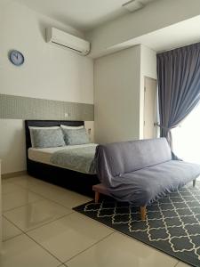 a bedroom with a bed and a couch in it at BS City Homestay2 - Miri Times Square in Miri