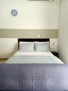 a bedroom with a bed with a clock on the wall at BS City Homestay2 - Miri Times Square in Miri