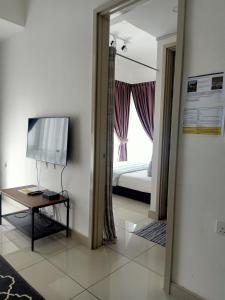 a room with a bed and a table and a mirror at BS City Homestay2 - Miri Times Square in Miri