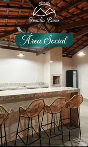 a bar with three chairs in front of a counter at Pousada Família Bueno in Monte Alegre do Sul