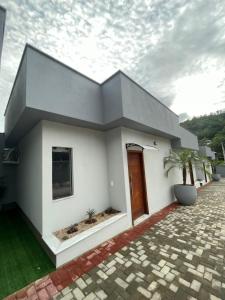 a white house with a brown door at Pousada Família Bueno in Monte Alegre do Sul