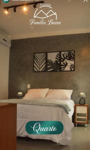 1 dormitorio con 1 cama con un cartel en la pared en Pousada Família Bueno, en Monte Alegre do Sul
