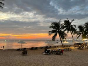 een strand met stoelen en parasols bij zonsondergang bij Amorii Hotel in Phu Quoc