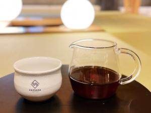 東京にあるMIMARU SUITES Tokyo Nihombashiのグラスマグカップの横でのコーヒー