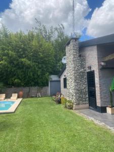 un patio trasero con piscina y un edificio de piedra en La boyita quinta en 