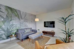 a living room with a blue couch and a tv at Beachy&Boho apt for 6 people with kitchen and pool in Fort Lauderdale