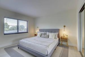 a bedroom with a large bed and a window at Beachy&Boho apt for 6 people with kitchen and pool in Fort Lauderdale