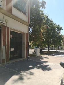 un bâtiment avec un garage et un arbre à côté dans l'établissement Casa Trezza 2, à Latina