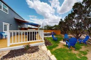 a deck with blue chairs and a table and an umbrella at Blue Oasis in the Hill Country in Kerrville
