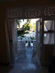 Cozy Villa Escape في راناوي باي: باب مفتوح على شرفة مع كراسي وطاولة