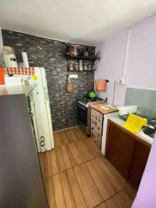 a kitchen with a wooden floor and a kitchen with a stove at Humilde espacio en el corazón de Minas in Minas