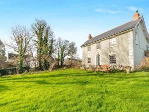 a white house with a large grass yard at Maclaren House in Milford Haven