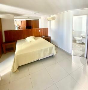 a bedroom with a bed and a bathroom with a toilet at Fabulosa Suite 903 em Flat Alto Padrão in Londrina