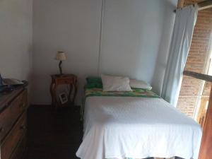 1 dormitorio pequeño con 1 cama, vestidor y ventana en Arrullo del viento en Villa Yacanto
