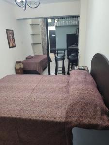 a bedroom with a bed and a living room with a piano at Departamento Calle Corrientes in San Miguel de Tucumán