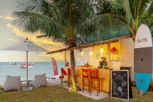 ein Restaurant am Strand mit einer Bar und Surfbrettern in der Unterkunft U Samui in Bangrak Beach
