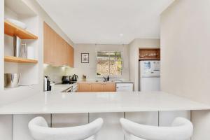 a white kitchen with white counters and white appliances at Villa 3br Bordeaux located within Cypress Lakes Resort in Pokolbin