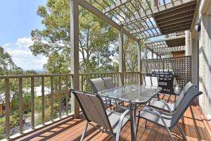 a patio with a table and chairs on a deck at Villa 3br Bordeaux Villa located within Cypress Lakes Resort in Pokolbin