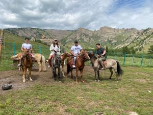 un grupo de personas montando caballos en un campo en Four Season en Ulán Bator