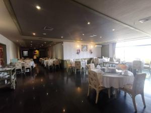 uma sala de jantar com mesas e cadeiras com toalhas de mesa brancas em LEE PLACE HOTEL em Banguecoque