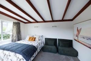 1 dormitorio con 1 cama y 1 silla en Rowling Road Studio, en Kaiteriteri