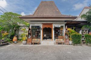 een klein gebouw met een boekenwinkel met stoelen bij Vinna Villa Seminyak by The Wina Resorts in Kerobokan