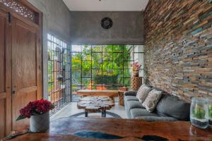 a living room with a couch and a brick wall at Vinna Villa Seminyak in Kerobokan