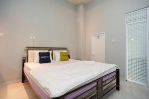 1 dormitorio con 1 cama con 2 almohadas en Urbanview Hotel Pangeran Palembang by RedDoorz en Palembang