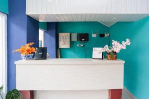 eine Rezeption in einem Zimmer mit blauer Wand in der Unterkunft Urbanview Hotel Pangeran Palembang by RedDoorz in Palembang