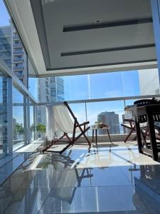 una silla sentada en un suelo de cristal en un edificio en Miami Boulevard II excelente, a 100 metros del mar en Punta del Este