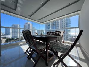 a dining room table with two chairs and a large window at Miami Boulevard II excelente, a 100 metros del mar in Punta del Este