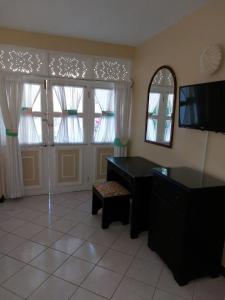uma sala de estar com uma secretária e 2 janelas em Cozy Villa Escape em Runaway Bay