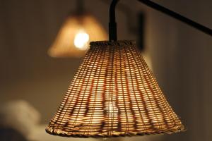 a brown wicker lamp hanging from a wall at Hacienda Del Sol in Taos