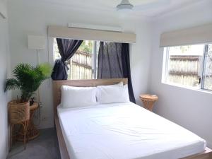 um quarto com uma grande cama branca e uma janela em Coral Reef Resort em Cairns