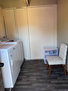 eine Küche mit einer Waschmaschine, einem Stuhl und einem Tisch in der Unterkunft Centrally Located near Hospital in Modesto