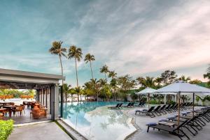 a resort pool with tables and chairs and palm trees at The Culture Samui in Bangrak Beach