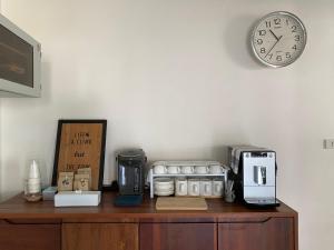 a clock on a wall above a counter with appliances at The 9th House in Krabi town