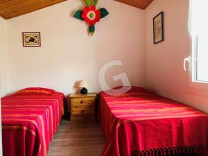 dwa łóżka w pokoju z czerwoną pościelą w obiekcie "Charmante maison proche plage pour 4 pers. à La Tranche sur Mer avec jardin et parking privé" - FR-1-357-296 w mieście La Tranche-sur-Mer
