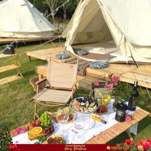 a table with a bunch of food and a tent at Đào Hoa Glamping in Hanoi