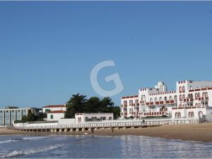widok na plażę z molo i budynki w obiekcie "Charmante maison proche plage pour 4 pers. à La Tranche sur Mer avec jardin et parking privé" - FR-1-357-296 w mieście La Tranche-sur-Mer